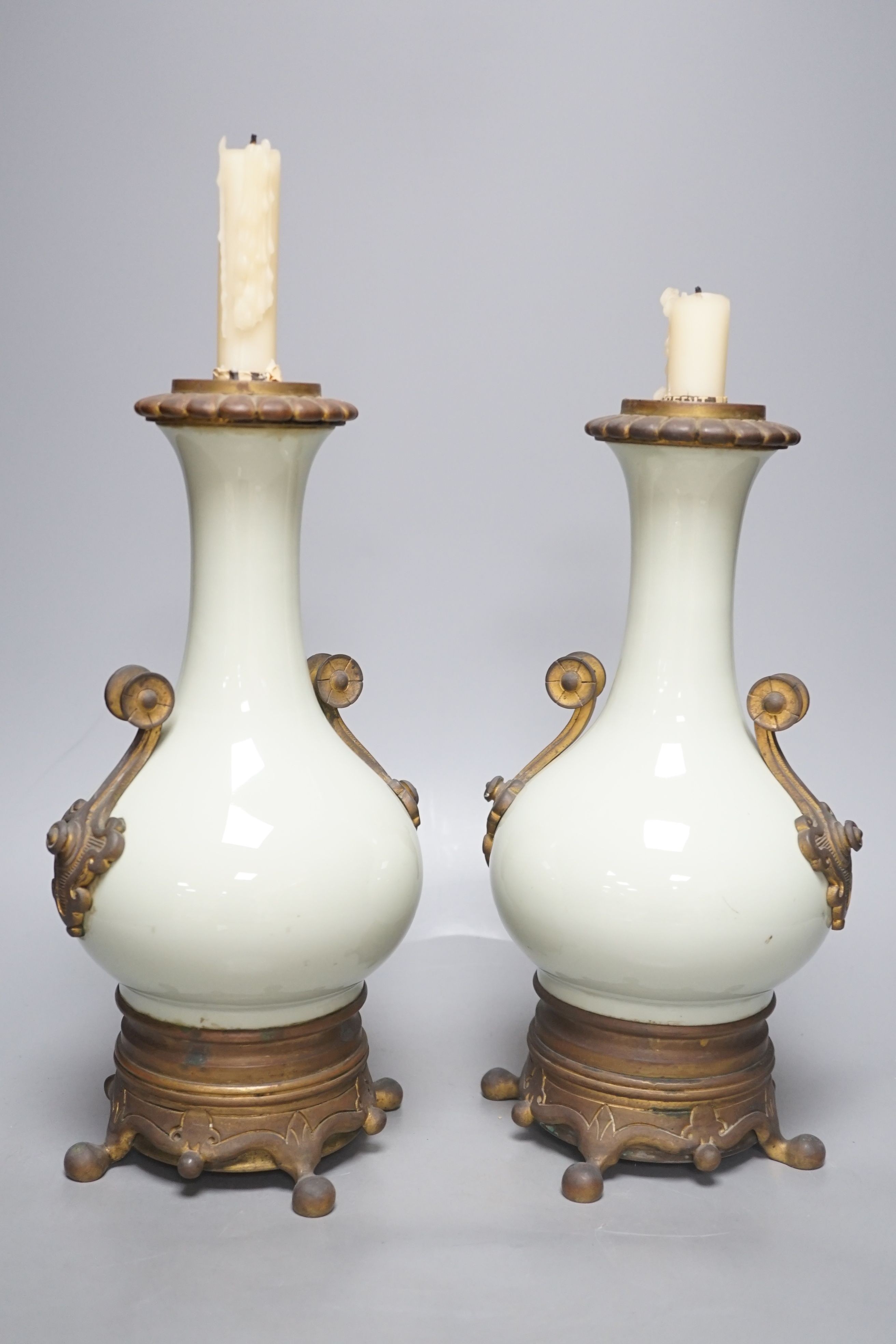 A pair of French celadon ground vases, now used as candlestands, total height 30cm